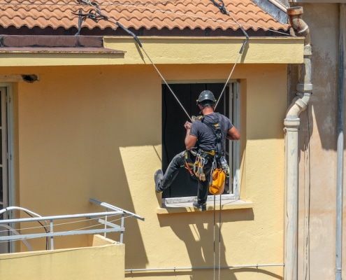Artisan en train de faire le ravalement d'une façade